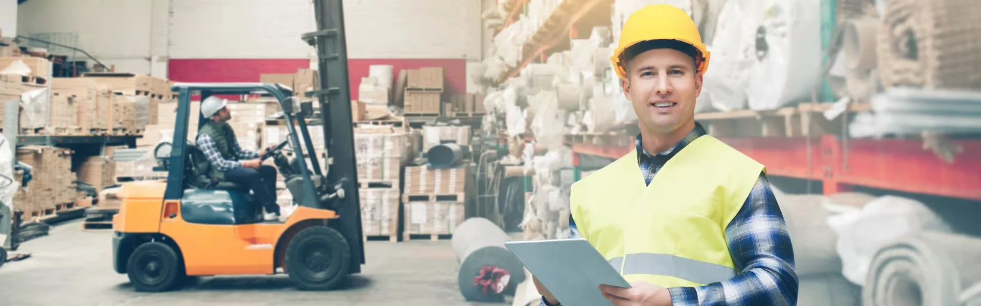 A warehouse manager and a worker operating the forklift